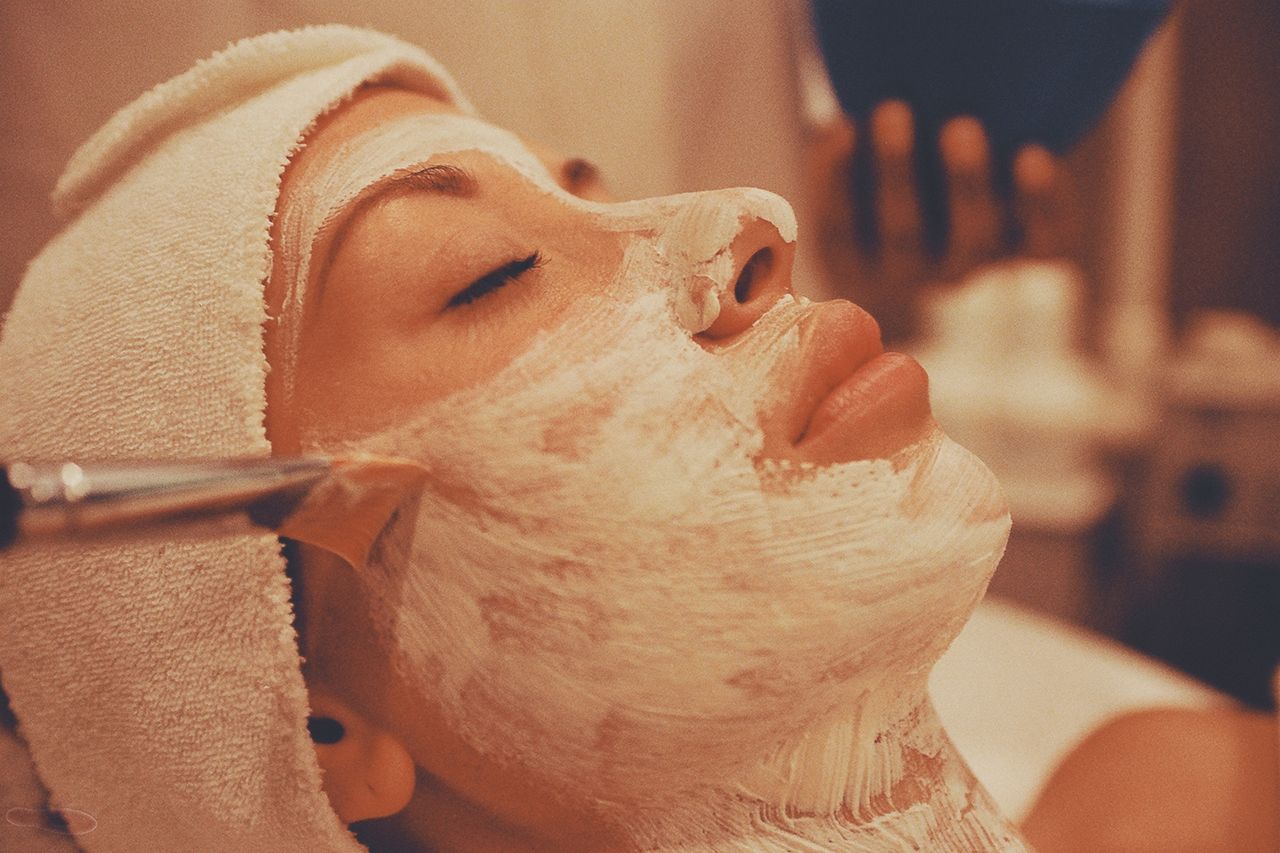 Features A calming spa facial treatment with a woman receiving a luxurious face mask application.